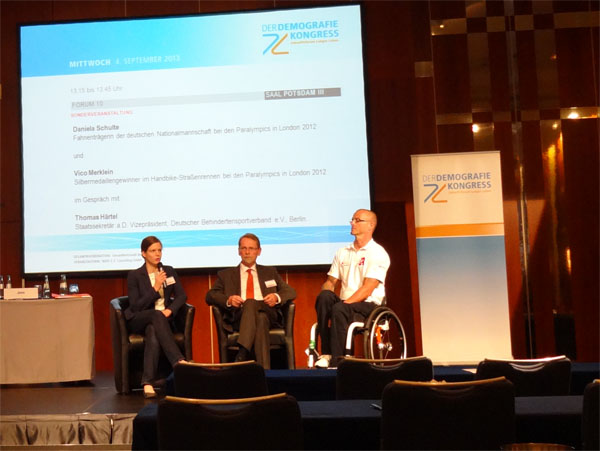 Auf dem Podium des Demografie Kongress 2013 im Hotel InterContinental im Gespr&auml;ch mit Staatssekret&auml;r a.D. Thomas H&auml;rtel und dem Handbiker Vico Merklein