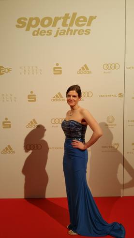 Ich auf dem roten Teppich der Gala Sportler des Jahres in Baden-Baden in meinem neues Sherri Hill Kleid ist ganz in Dunkelblau gehalten und auf H&ouml;he der B&uuml;ste mit zahllosen Steinen in verschiedenen Blaut&ouml;nen verziert.